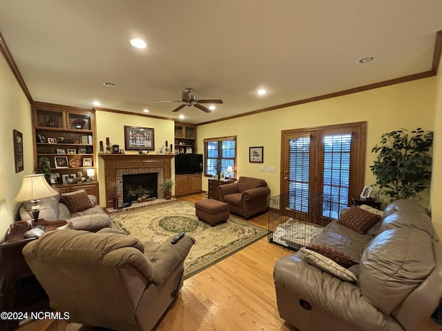 living room with a fireplace, a healthy amount of sunlight, light hardwood / wood-style flooring, and ceiling fan