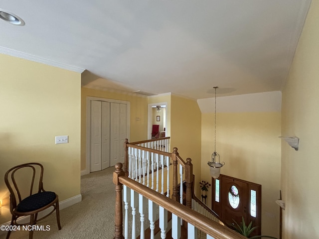 hall featuring baseboards, carpet flooring, an upstairs landing, and crown molding