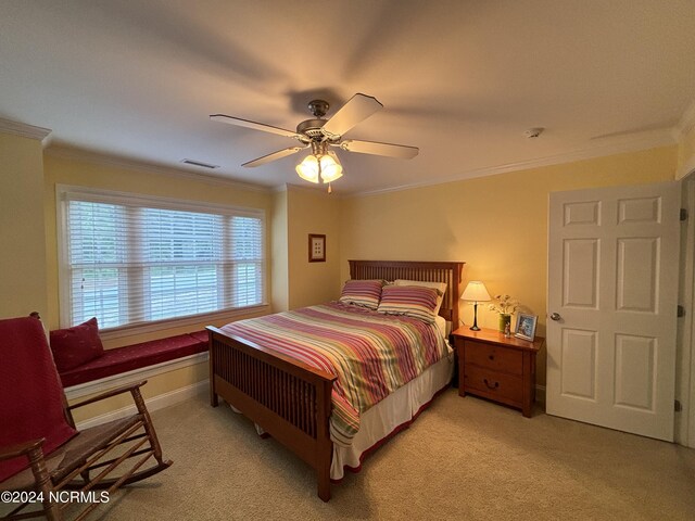 bedroom with crown molding, baseboards, and light colored carpet