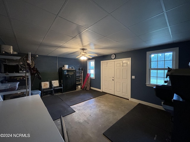 interior space featuring concrete floors, ceiling fan, and a paneled ceiling