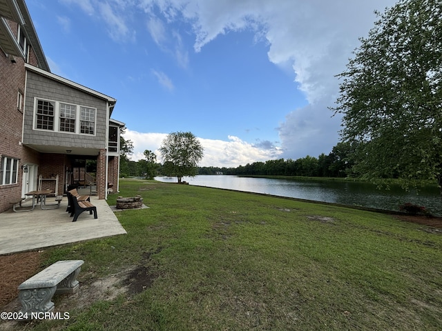 view of yard with a patio area, a water view, and a fire pit