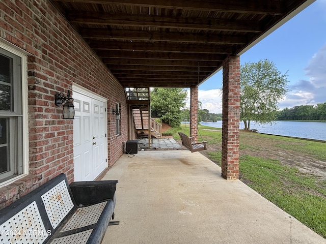 view of patio / terrace with a water view and stairs