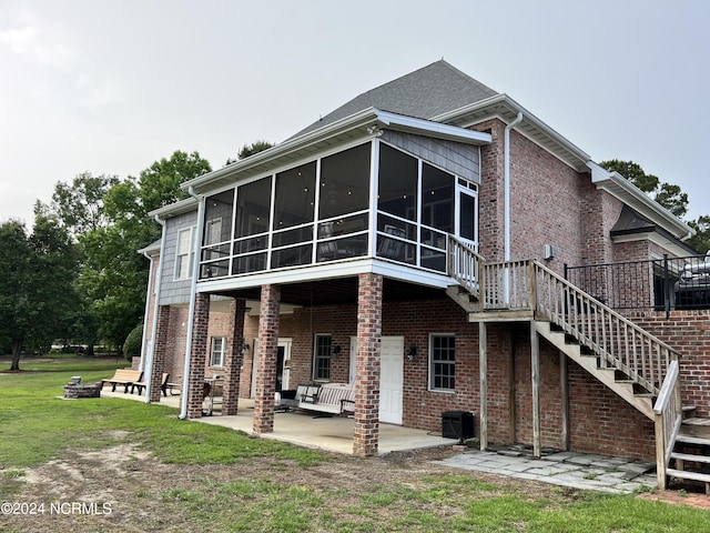 rear view of house featuring a sunroom, a patio, and a yard