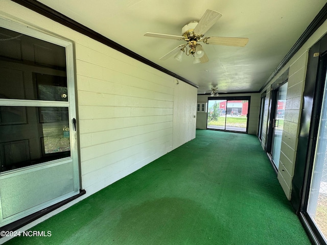 unfurnished sunroom featuring ceiling fan