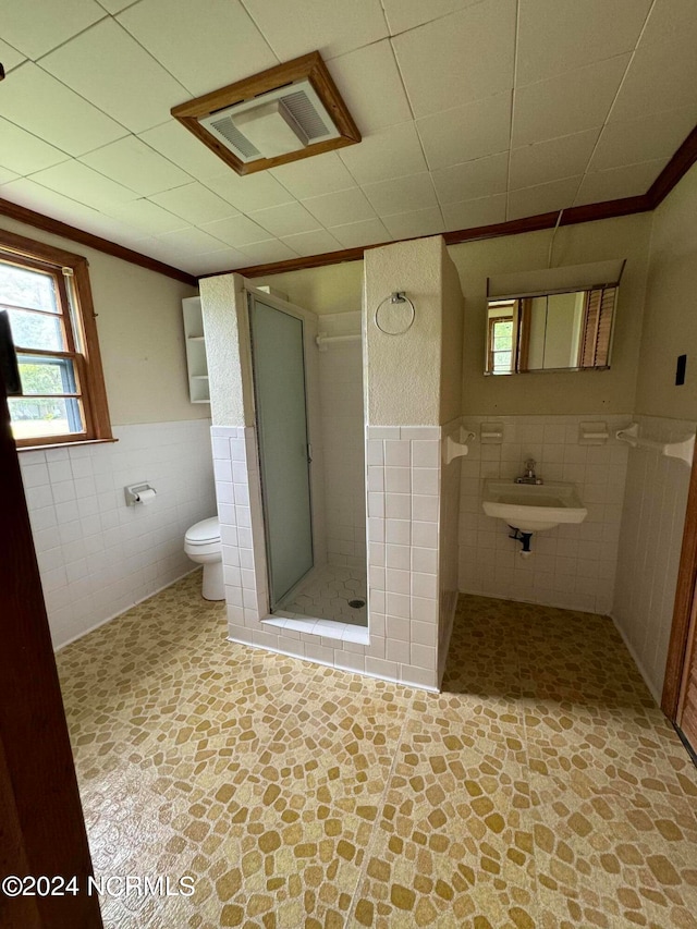 bathroom featuring tile floors, toilet, and tile walls