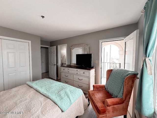 bedroom featuring wood-type flooring and access to outside