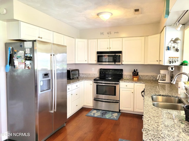 kitchen featuring stainless steel appliances, dark hardwood / wood-style flooring, light stone counters, and white cabinetry