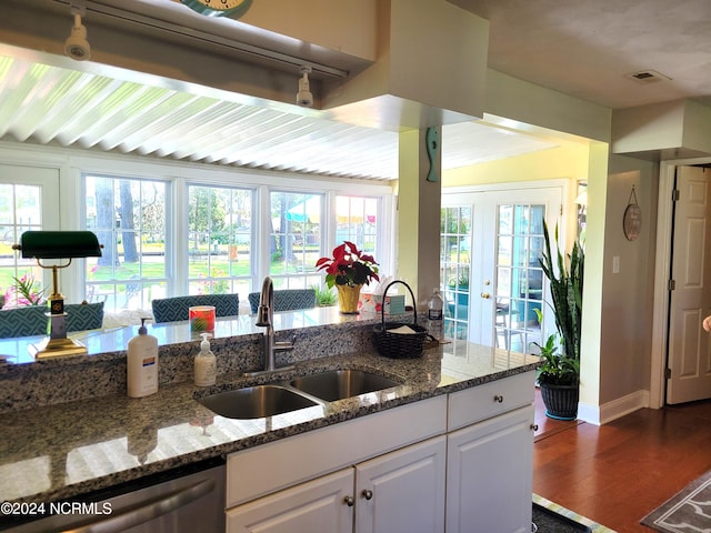 kitchen with dishwasher, a healthy amount of sunlight, french doors, and wood-type flooring