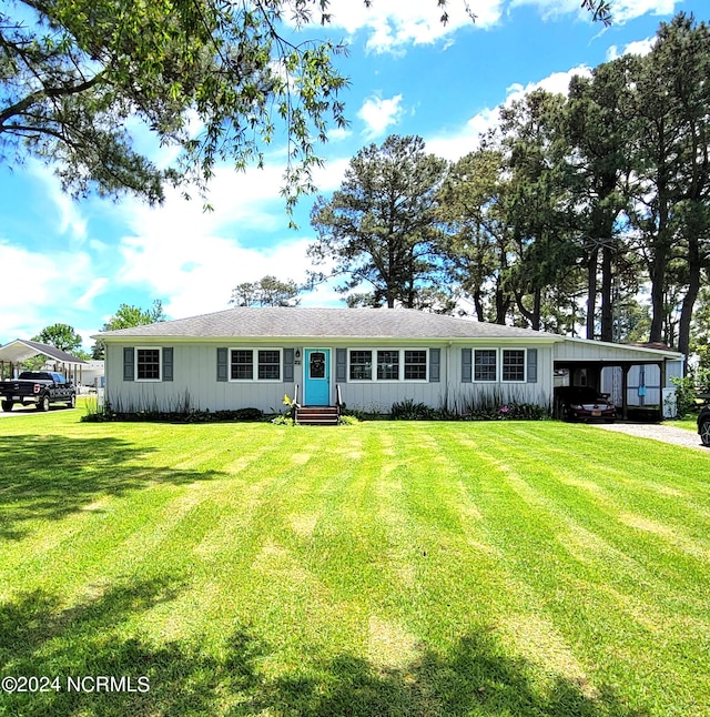 view of front of home with a carport and a front lawn