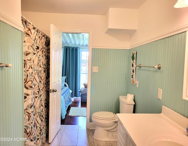 bathroom featuring tile floors, vanity, and toilet