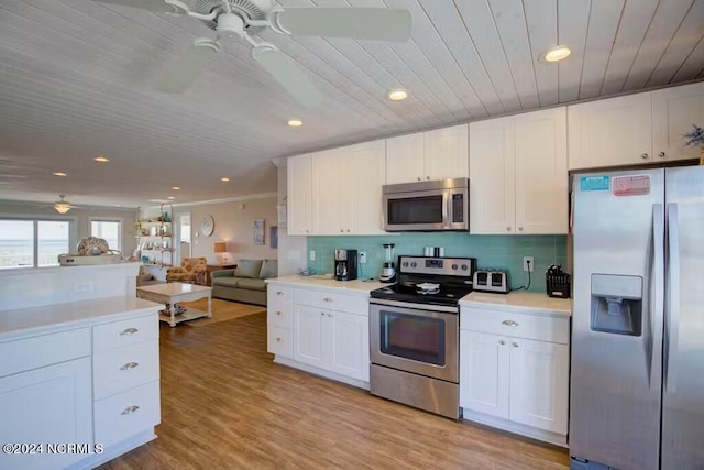 kitchen featuring stainless steel appliances, white cabinets, ceiling fan, and light wood-type flooring