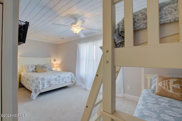 bedroom with ceiling fan, crown molding, carpet flooring, and wood ceiling