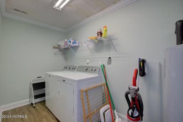 laundry area with washer and dryer, light hardwood / wood-style floors, and crown molding