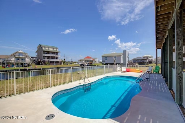 view of pool with a lawn and a patio