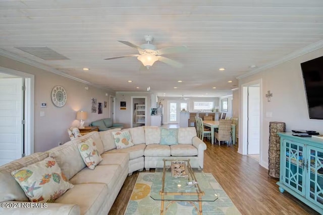 living room featuring crown molding, wood-type flooring, and ceiling fan