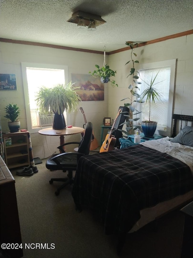 carpeted bedroom with a textured ceiling and ornamental molding