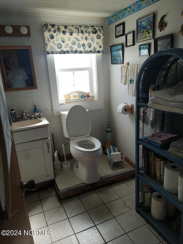 bathroom with tile floors, vanity, and toilet