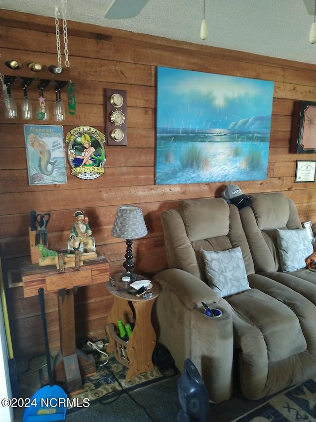 living room with a textured ceiling and wooden walls