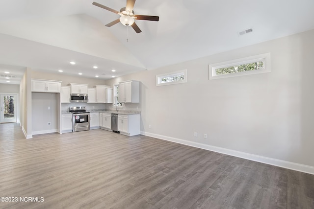 unfurnished living room with sink, wood-type flooring, high vaulted ceiling, and ceiling fan