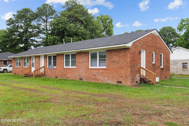 ranch-style home featuring entry steps, crawl space, brick siding, and a front lawn