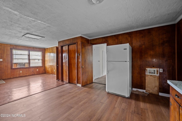 kitchen with brown cabinetry, freestanding refrigerator, light countertops, and light wood finished floors