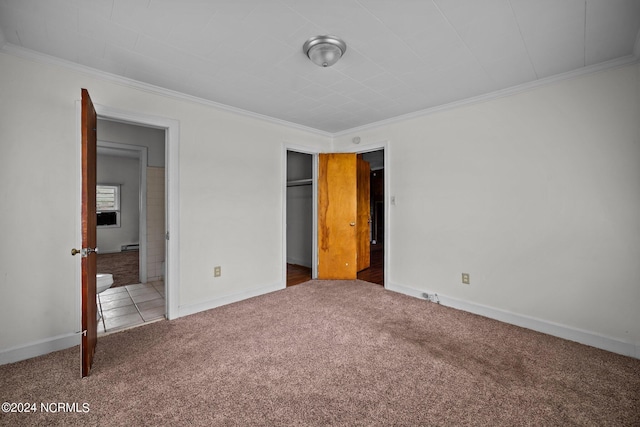 unfurnished bedroom featuring carpet floors, crown molding, and baseboards