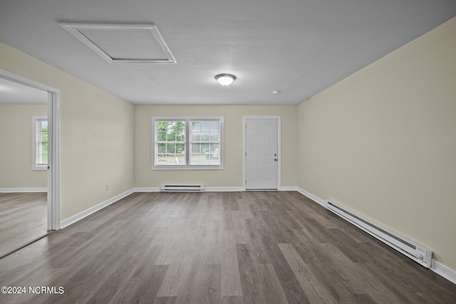 unfurnished room with a wealth of natural light, a baseboard radiator, and attic access