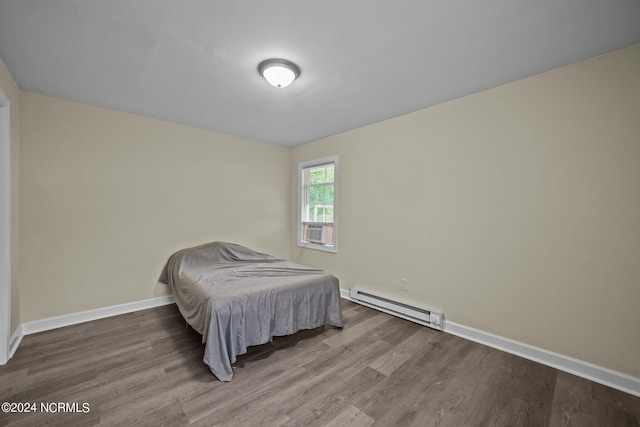 bedroom with cooling unit, a baseboard radiator, baseboards, and wood finished floors