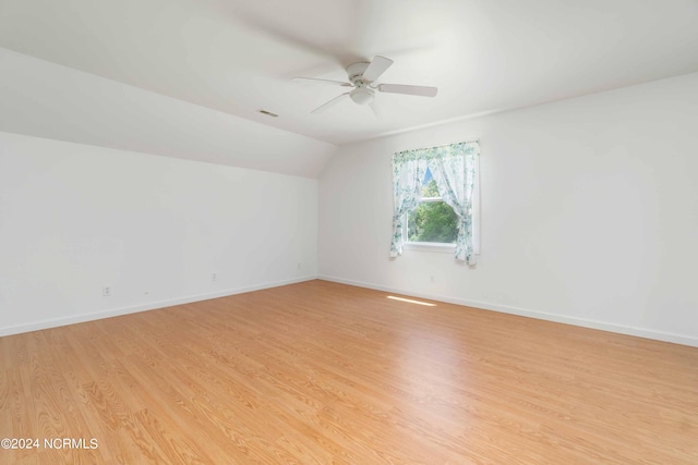 unfurnished room with lofted ceiling, ceiling fan, and light hardwood / wood-style flooring