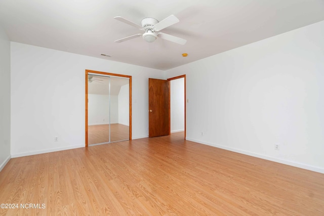 unfurnished bedroom featuring light hardwood / wood-style floors, a closet, and ceiling fan