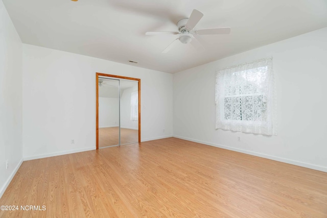 unfurnished bedroom with ceiling fan, a closet, and light hardwood / wood-style floors