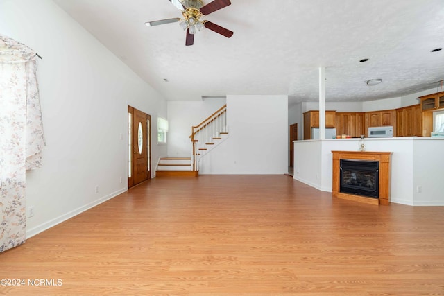 unfurnished living room with light hardwood / wood-style floors and ceiling fan