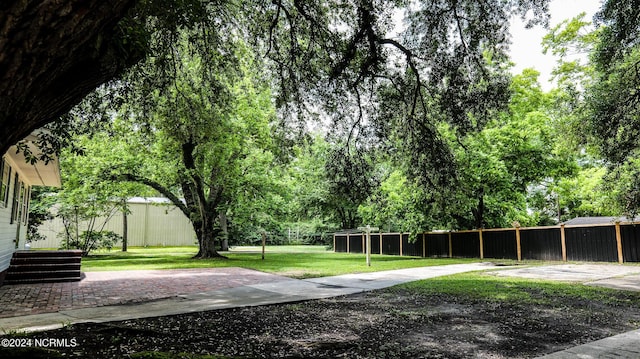 view of home's community with a yard and fence