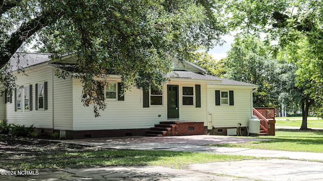 view of front of property with crawl space, roof with shingles, and a front lawn