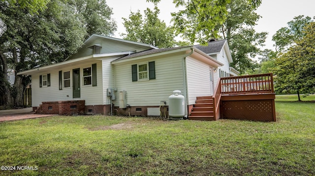 rear view of house with a shingled roof, crawl space, a lawn, and a wooden deck