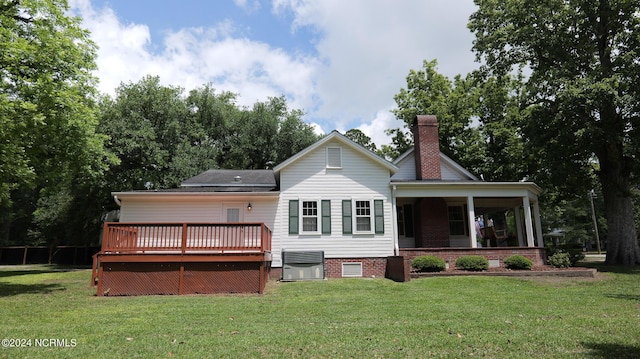 back of house with crawl space, a wooden deck, a chimney, and a yard