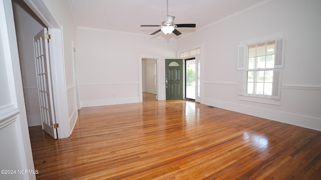 spare room featuring ornamental molding, light wood-style floors, and baseboards