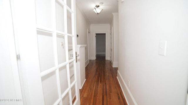 hallway featuring dark wood-style floors, ornamental molding, and baseboards