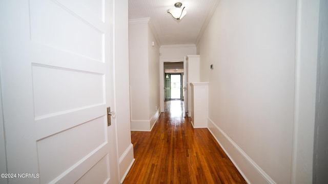 hallway featuring baseboards, dark wood finished floors, and crown molding