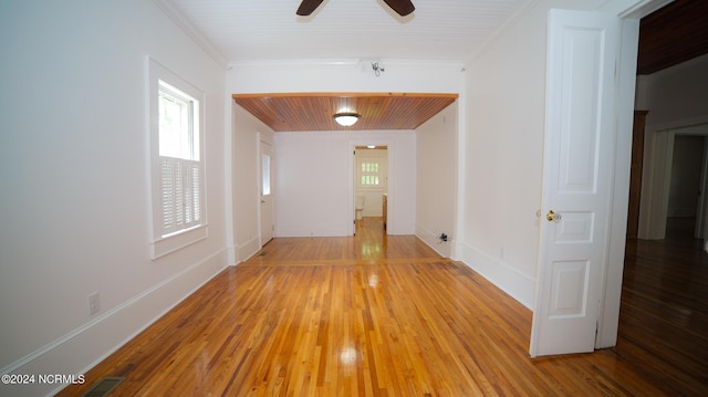 spare room featuring baseboards, light wood finished floors, a ceiling fan, and crown molding