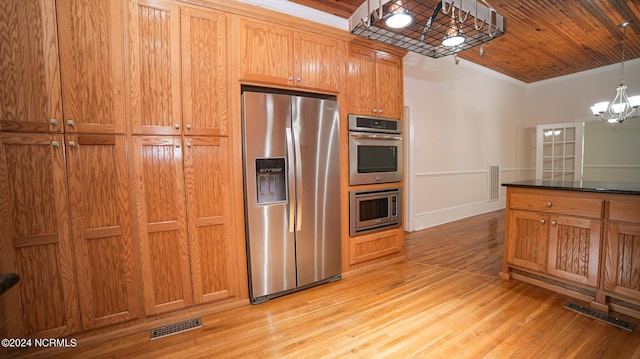 kitchen with appliances with stainless steel finishes, visible vents, a notable chandelier, and light wood finished floors