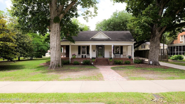 bungalow-style home featuring covered porch and a front lawn