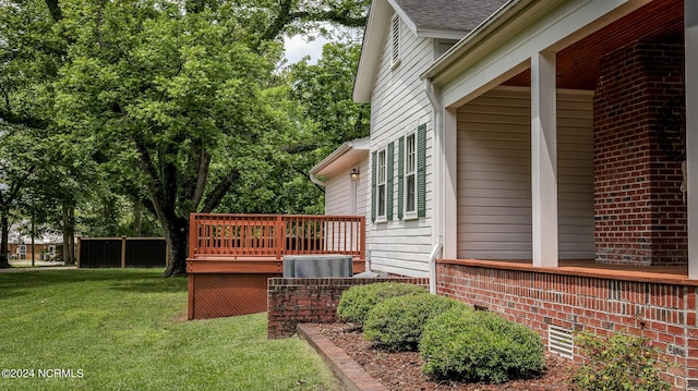 view of side of property with brick siding, central air condition unit, a shingled roof, a lawn, and a wooden deck