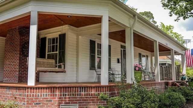 view of property exterior with a porch and brick siding