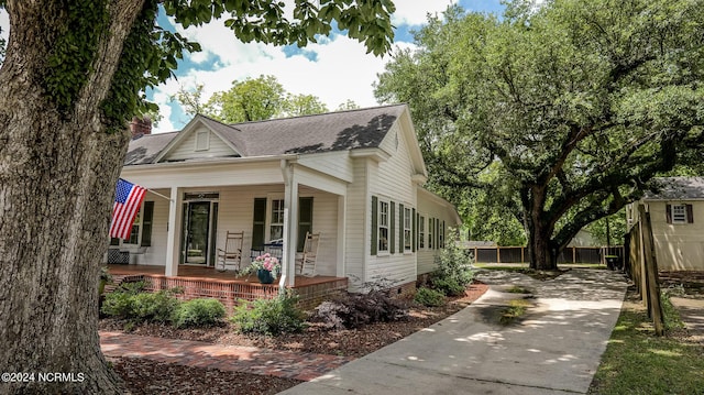 bungalow-style home with covered porch and roof with shingles