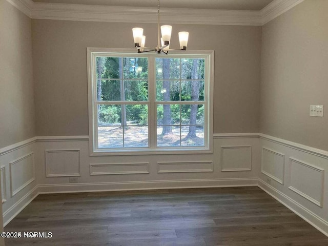 unfurnished dining area with crown molding, dark hardwood / wood-style floors, and an inviting chandelier