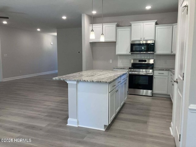 kitchen with light hardwood / wood-style flooring, white cabinetry, stainless steel appliances, light stone counters, and tasteful backsplash