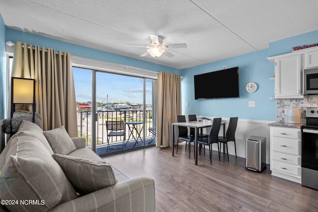 living room featuring a textured ceiling, ceiling fan, a healthy amount of sunlight, and hardwood / wood-style floors