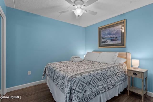 bedroom with ceiling fan, dark hardwood / wood-style flooring, and a textured ceiling