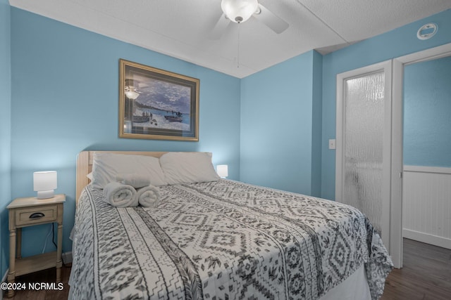 bedroom with a textured ceiling, dark hardwood / wood-style floors, and ceiling fan